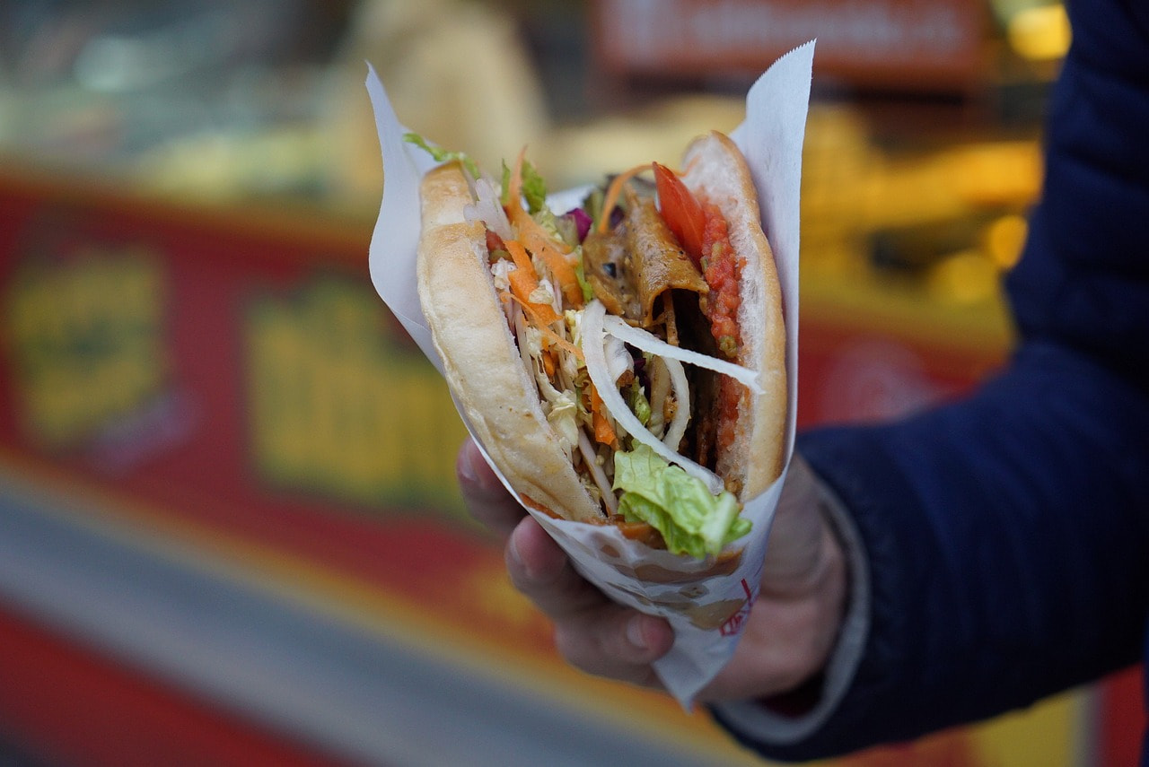 Ein Mann hat sich einen Döner zum Mitnehmen bestellt.